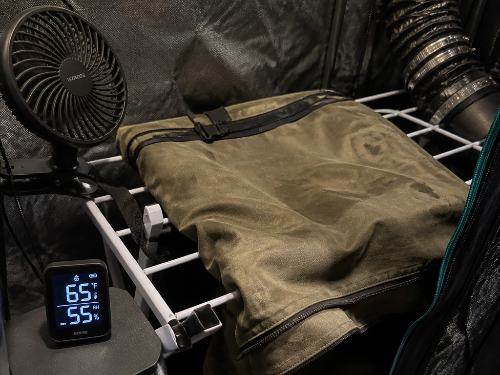 Inside a controlled dry tent setup for drying a canvas tent with fan and hygrometer.
