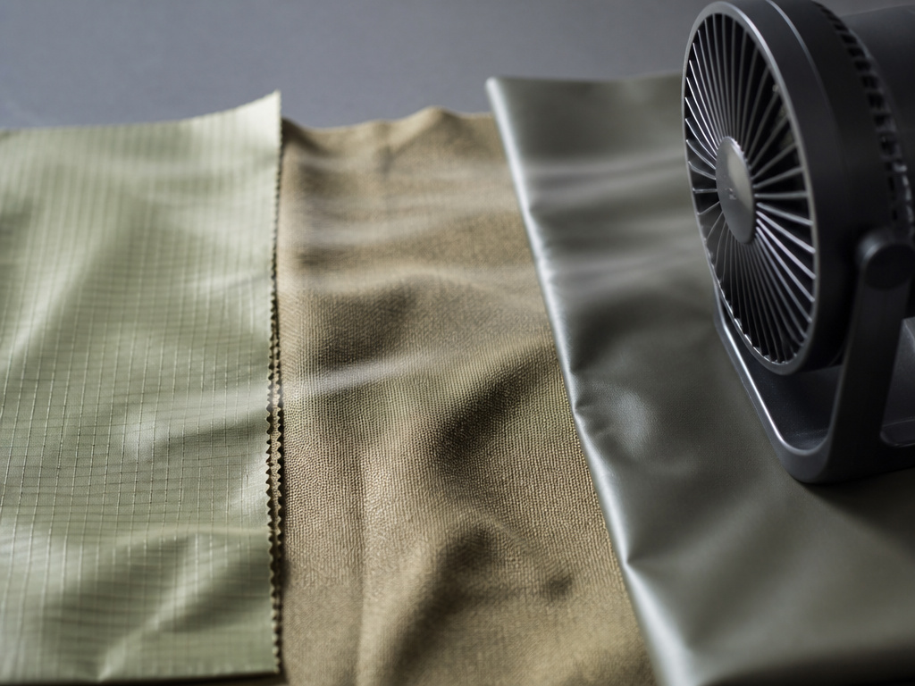 Close-up comparison of nylon, canvas, and vinyl tent fabrics drying with a fan.