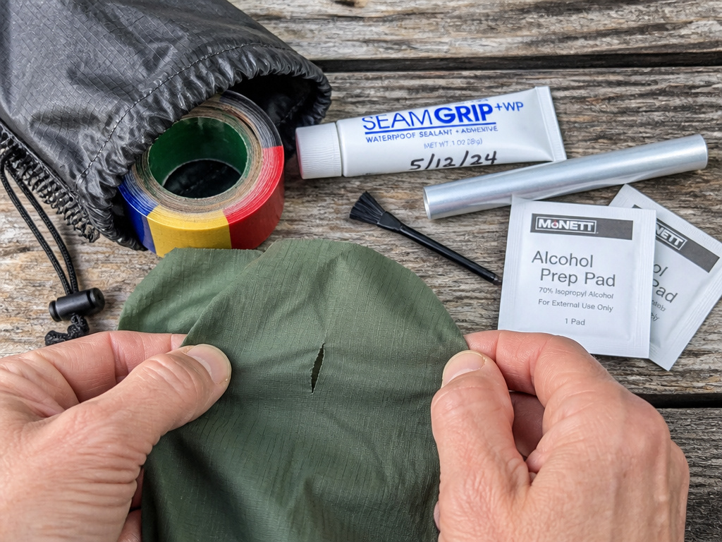 Essential tent repair kit items laid out for field fixes and maintenance.